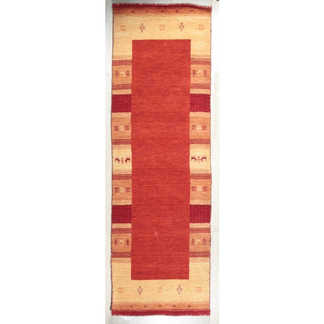 A hand-loomed wool rug, made in India and measuring 4' x 6'. Geometric drawing - repeating motifs held inside strong...
