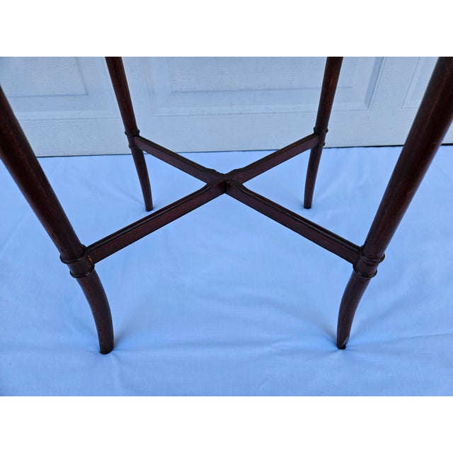 This charming Georgian style mahogany side table features one drawer and sabre-like legs connected by a stretcher. The...