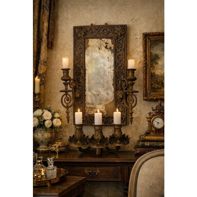 This striking antique wall mirror features an intricately cast metal frame in a Baroque Revival style, richly adorned with...