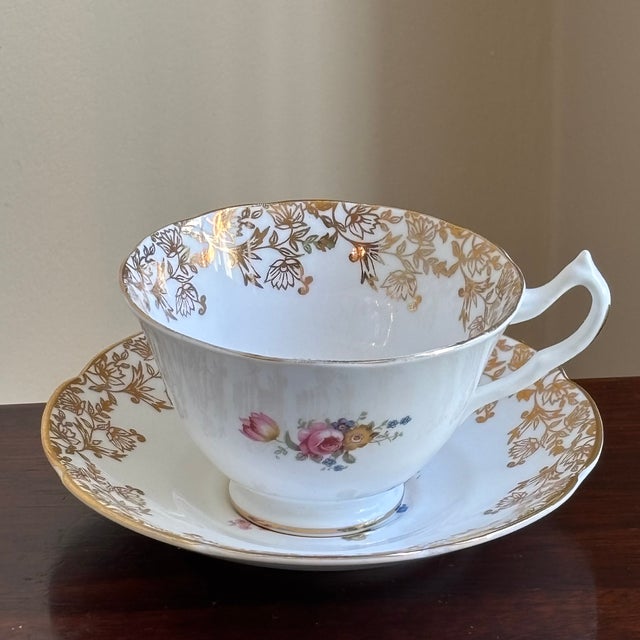 Offering a beautiful vintage bone china teacup and saucer by Collingwoods of England. This elegant set features delicate...