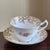 Offering a beautiful vintage bone china teacup and saucer by Collingwoods of England. This elegant set features delicate...