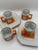 Vintage Trend by Nasco orange and white ceramic mug and saucer set featuring a retro geometric design. It comes with the...