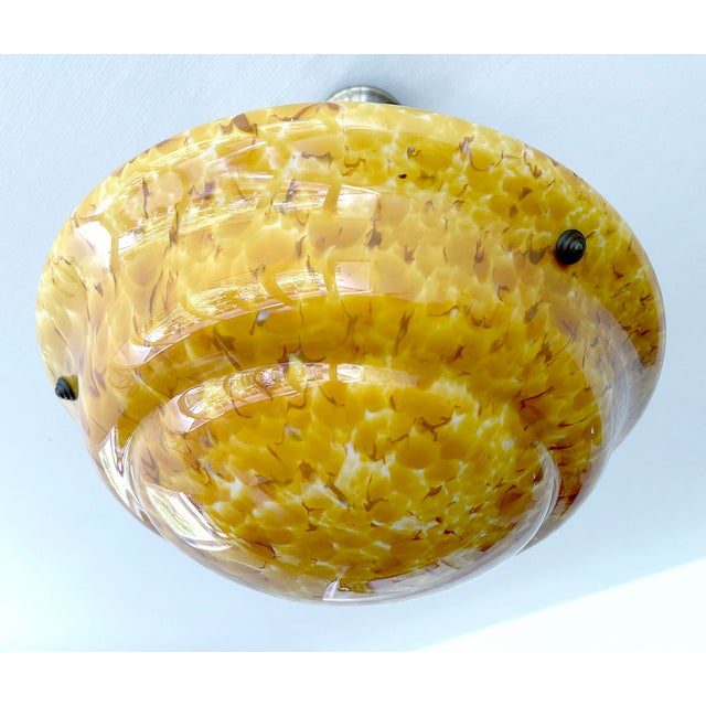 Art Deco pendant light from the 1930s, mottled overlay amber glass shade with fire patterns , the inside has a white glass...