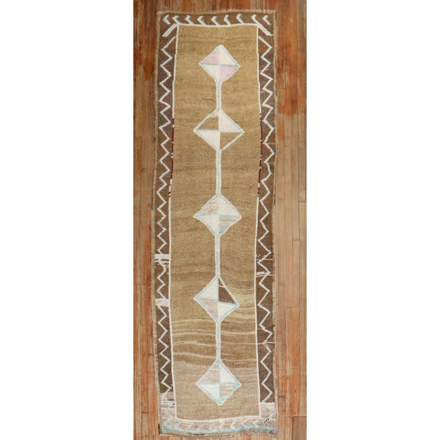 A Turkish runner with a geometric design on a brown field 3'4'' x 11'6''