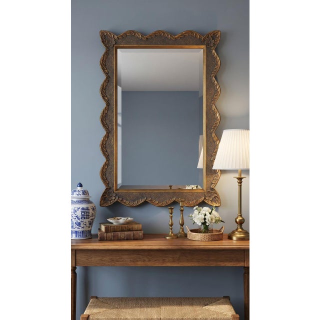 The Vail Wall Mirror features an ornate gold resin frame with sculpted detailing and beveled glass that bring a warm,...