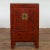 A Chinese Qing Dynasty period red lacquer bedside cabinet from the 19th century with hand-painted décor and golden...