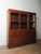 A stunning apothecary cabinet featuring 32 small drawers beneath a set of three glass-front sliding doors. Crafted from...