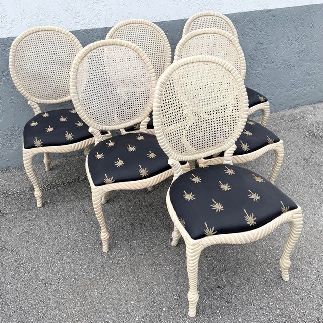 Striking set of six vintage French Provincial dining chairs featuring oversized oval cane backs and beautifully carved...