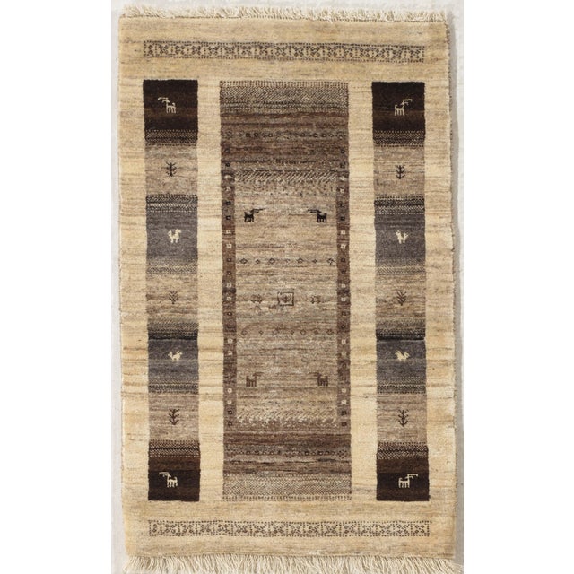 Hand-knotted Persian Lori wool rug featuring a central panel with small stylized animal figures, flanked by vertical bands...