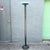 A striking vintage Postmodern torchiere floor lamp featuring a tall, streamlined profile with a reflective dark metal...