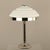 Table lamp with chromed hexagonal base, tiered white opal glass shade. This piece has an attribution mark, I am sure that...