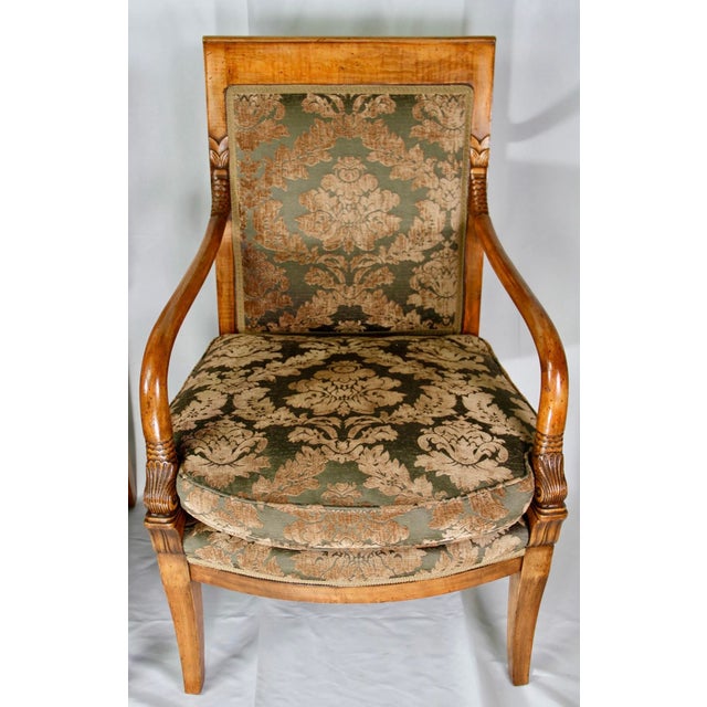 Elegant pair of mid-20th century French Directoire-style walnut armchairs, featuring gracefully curved open arms and...