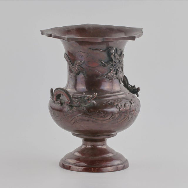 Bronze Chinese flower vase from the 19th century with waves and dragons motif on the body and handles. Picturesque and...