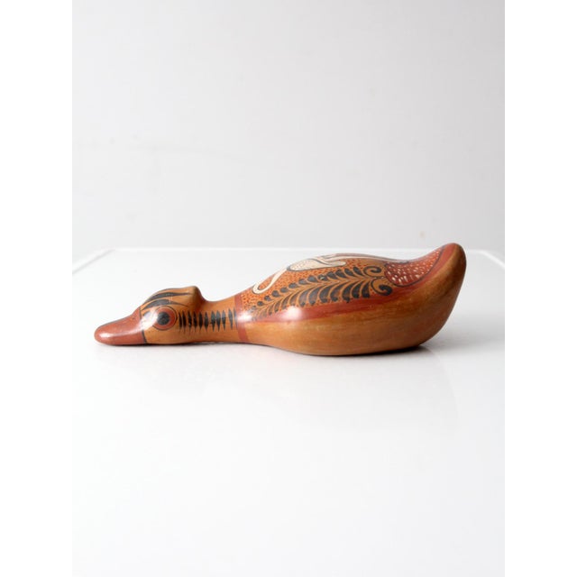 This vintage Tonalá duck figurine from Tonalá is hand-painted in layered terracotta tones with finely detailed foliate and...