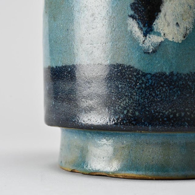Ceramic pot made by the Menelika pottery in the 1950s. Cylindrical in shape with a slightly flared neck, it features a...