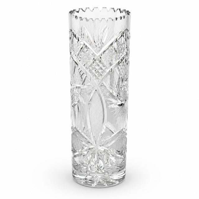 Striking tall cut-crystal vase featuring an elaborate geometric pattern of starbursts, fans, crosshatching, and deeply...