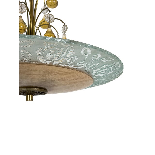 The plafond consists of a large circular glass shade with a warm champagne-toned center, surrounded by a broad border of...
