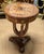 Bring timeless European elegance into your home with this exquisite French Empire style round accent table. Featuring a...