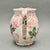 • This charming ceramic pitcher features a hand-painted pink rose motif with green leaf accents, created by The Haldon...