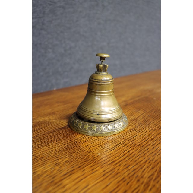 Antique brass table or service bell with a classic domed form and finely turned concentric detailing. The wide circular...