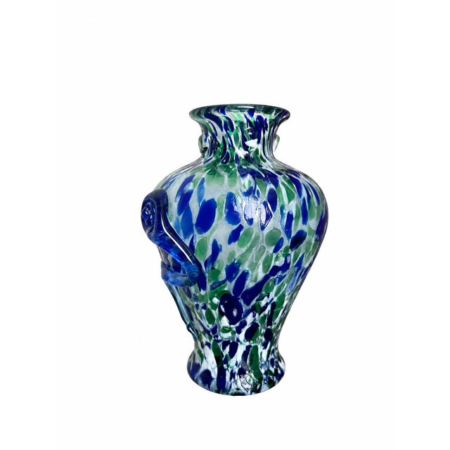 A sculptural art-glass vase featuring rich cobalt-blue and emerald-green patches against a cloudy pale ground with...