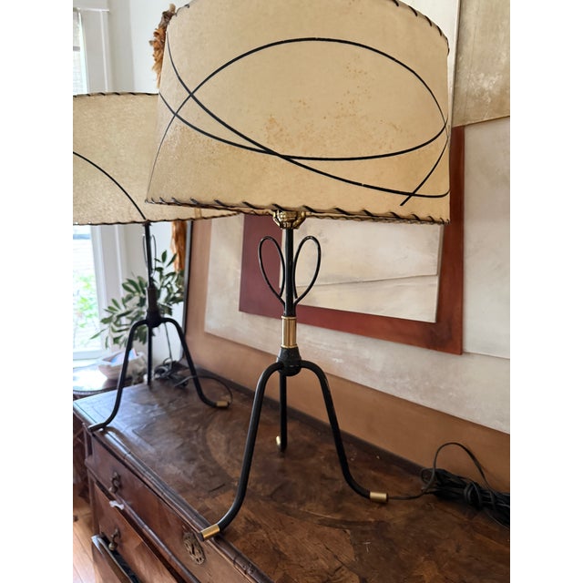 A striking pair of mid century modern table lamps with sculptural metal bases and original shades. The bases feature a...