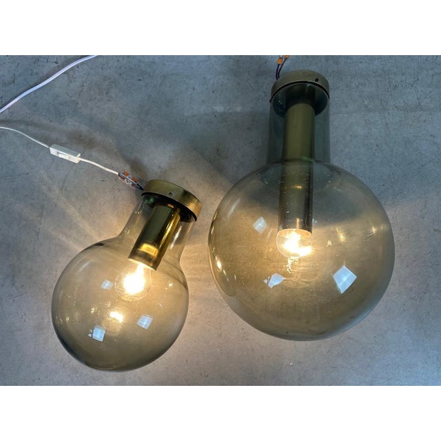 A duo from Raak. Model: Maxi Light Bulb. Very solid fixture in brass and porcelain. Fumigated globes in the shape of a...