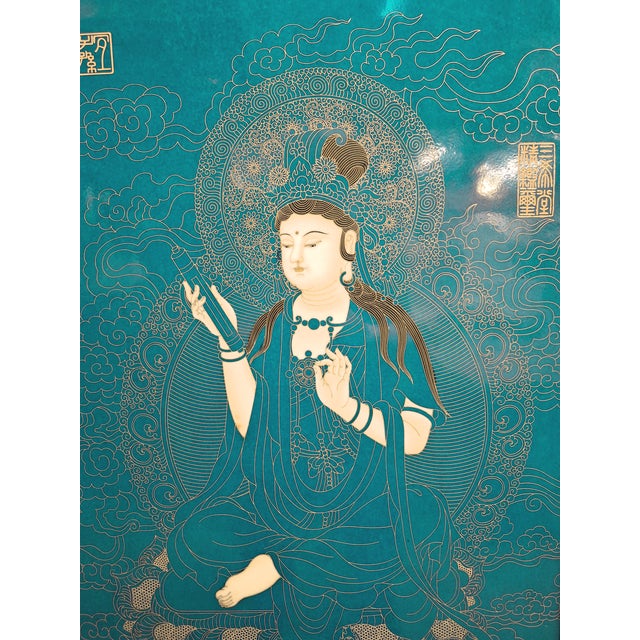 Chinese framed porcelain Buddhist temple plaque, a finely drawn depiction of Kuan Yin, in turquoise and gold, seated on a...