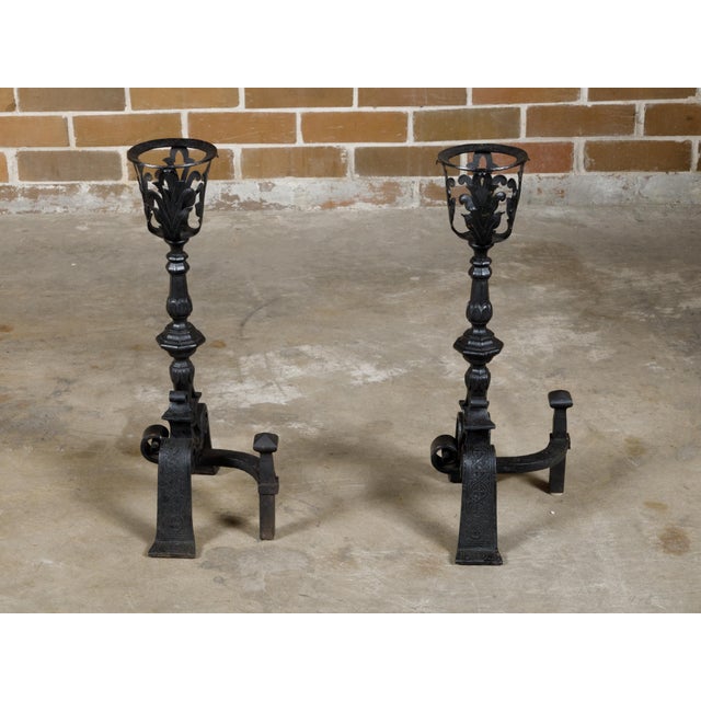 A pair of English Turn of the Century iron andirons from circa 1900 with foliage motifs and scrolling feet. This pair of...