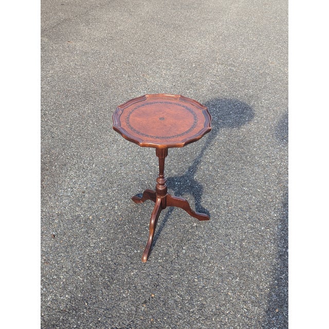Elevate your home decor with this exquisite mahogany candle stand, featuring a uniquely stenciled tan tooled leather top...