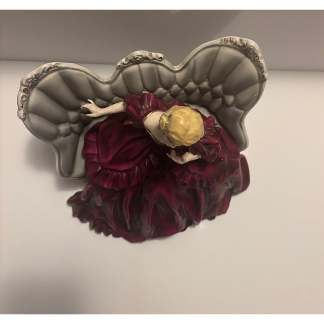 Lovely vintage ceramic figurine. The “Victoria” piece features an elegant Victorian-era lady in a rich burgundy dress...