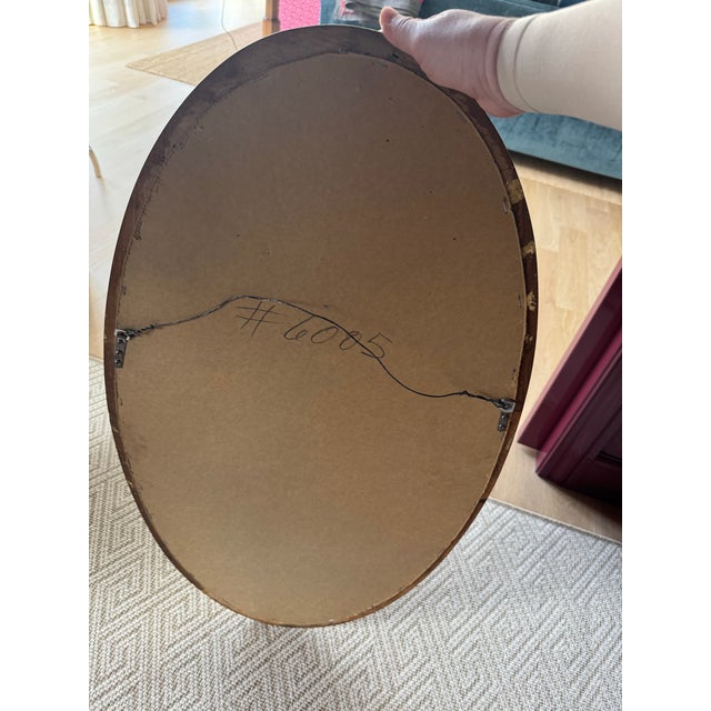 A matched, heavy pair of mid-century modern oval wall mirrors featuring a substantial, 2-inch deep carved wood frame with...