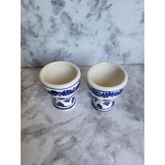 Vintage set of 2 Delft egg cups with traditional blue and white designs. These charming handpainted egg cups are fully...