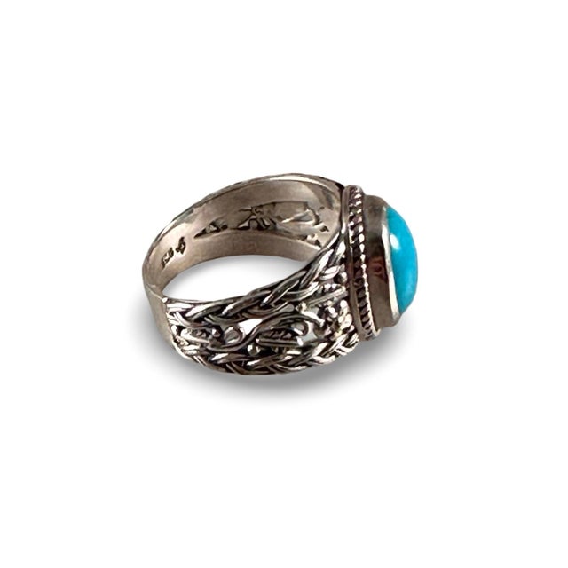 Beautiful Turquoise cabochon set in this sterling silver ring, size 7. Pretty floral detail enhances the band, while the...