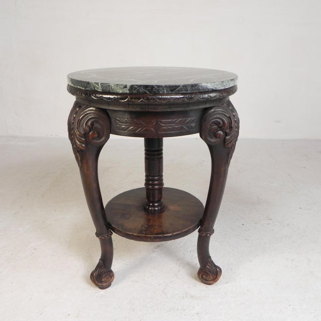 Elegant table from the early 20th century with a beautifully decorated mahogany base and a luxurious marble top. This...