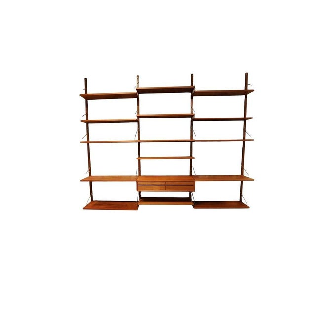 A generous teak shelving system with beautiful grain, warm wood tones and an airy expression. Slim wall rails and thin...