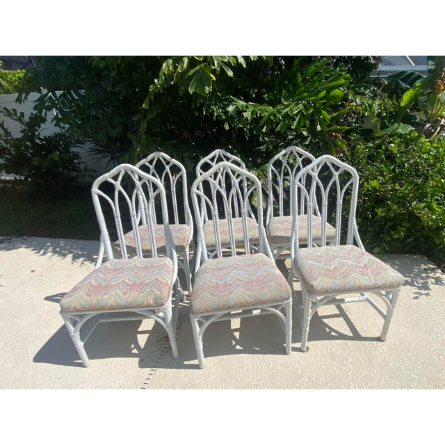 Offered is a set of six vintage Henry Link Cathedral rattan dining chairs. These iconic Hollywood Regency style pieces...