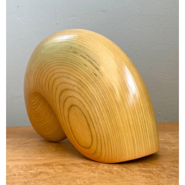 This masterfully carved nautilus shell sculpture is a quintessential example of Mid-Century Modern organic abstraction....