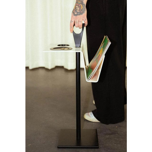 Space Age magazine rack composed of a white acrylic glass table with a black lacquered metal foot. Dimensions Width 32 cm...