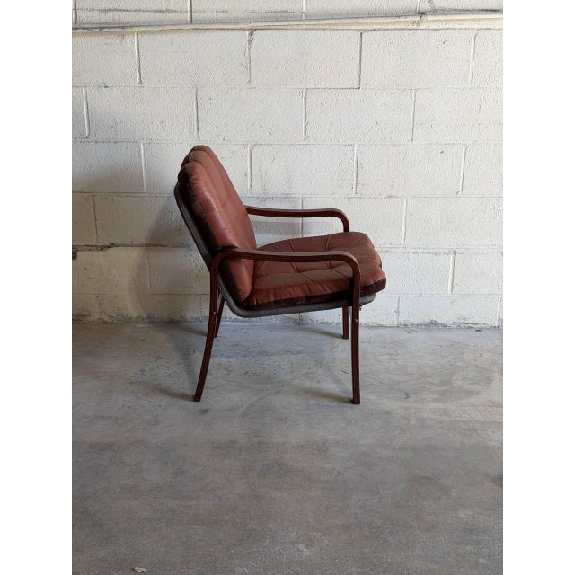 Vintage Danish Mid Century Modern lounge chair featuring a sculptural solid rosewood frame with original tufted leather...
