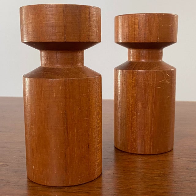 Pair of vintage solid teak candle holders with brass inserts marked "Made In Denmark" on bases. Ships quickly via USPS.