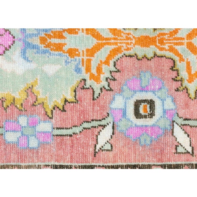 This vintage Turkish Oushak rug, measuring 2'11" by 5'10", is handwoven with wool on a wool foundation in the Oushak...