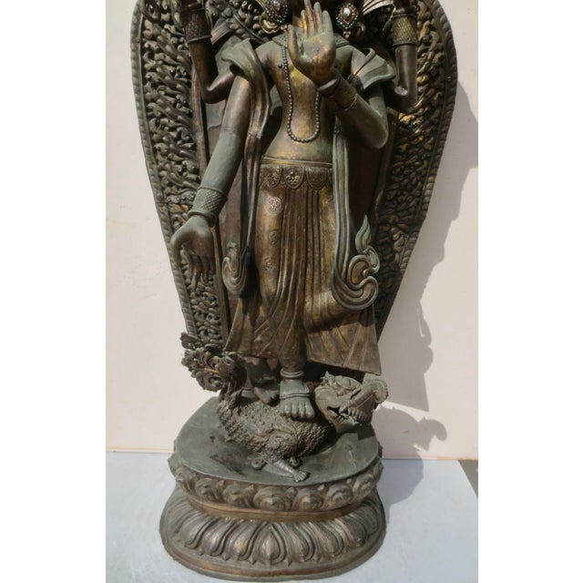Four-armed standing figure of Manjusri with the sutra book and mala beads in the upper hands and the lower hands in mudra...