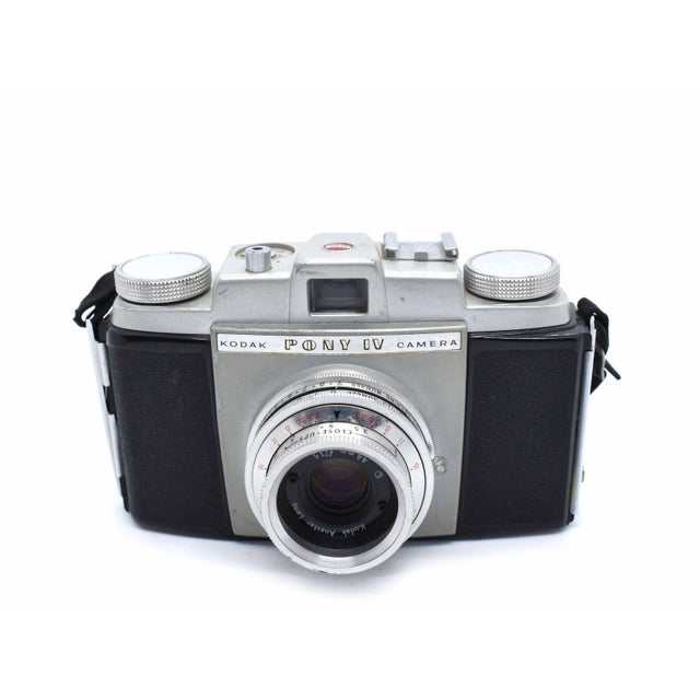 This vintage Kodak Pony IV 35mm camera, manufactured between 1957 and 1961, is a quintessential piece of American mid-...