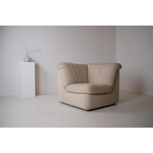 Rare corner lounge chair, probably dating from the late 1970s or the 1980s. Fully upholstered, it is distinguished by its...
