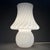 An iconic, single-piece mushroom-shaped table lamp in white opaline glass with a swirling spiral design, attributed to the...