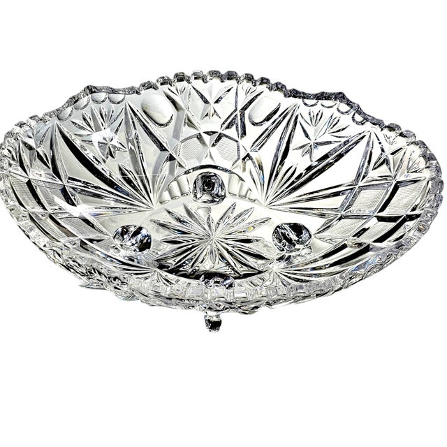 This vintage footed crystal bowl is festooned with stars around the saw tooth rim. The cuts in the bottom arches are...