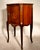 Elegant French Louis XV-style side cabinet crafted in mahogany with finely figured veneers, floral marquetry inlay, and...