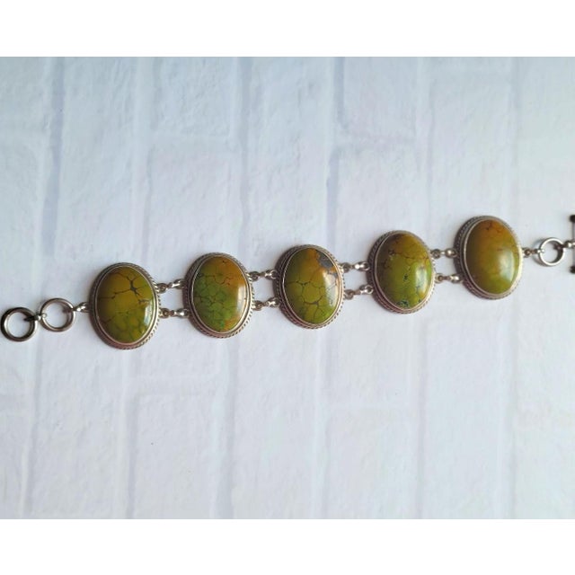 Introducing a remarkable vintage sterling silver bracelet believed to be of Native American origin, featuring five...