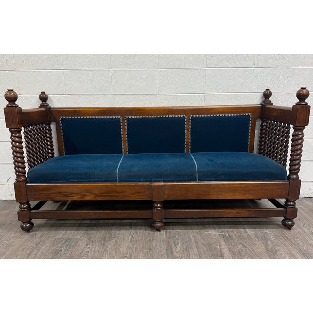 This is a stunning antique Jacobean Revival oak hall settee, daybed, or bench featuring richly carved barley twist...